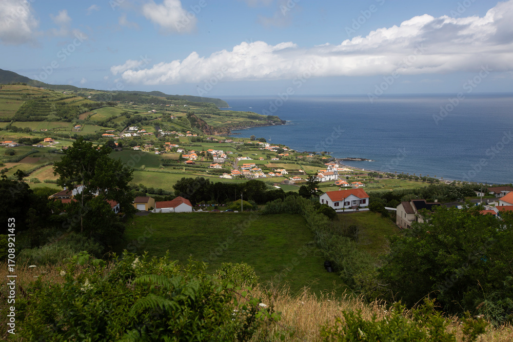 Fototapeta premium Faial, Azores, island, Portugal, Beautiful view of a small town with houses and a beach. The houses are white and the beach is blue