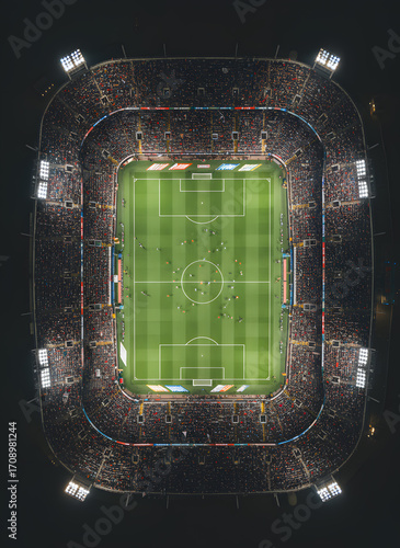 Aerial view of a bustling sports stadium filled with spectators, showcasing the excitement of a thrilling soccer match at night.