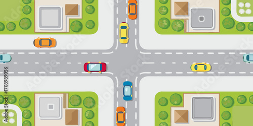 Aerial view of a suburban intersection with cars driving on roads and houses with green lawns