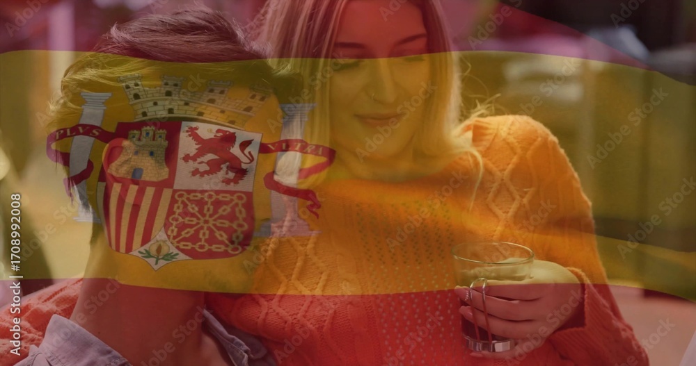 Fototapeta premium Sitting couple sharing moment in home living room, with clear glass mug and Spanish flag overlay