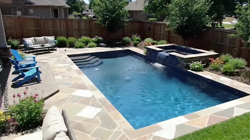 Backyard Swimming Pool with Beige Pavement and Wooden Fence Under Daylight