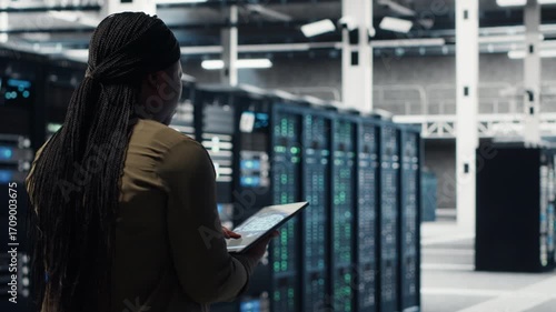 Data center software developer doing AI data analysis on tablet to upgrade infrastructure. Server hub IT expert using device to manage storage systems for deep learning training datasets