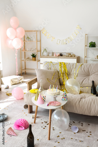 Interior of messy living room after Birthday celebration with sofa, table and...