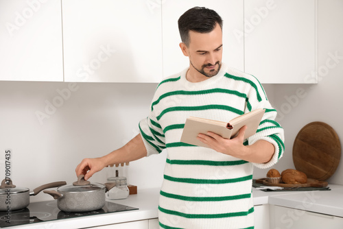 Handsome man reading book w...