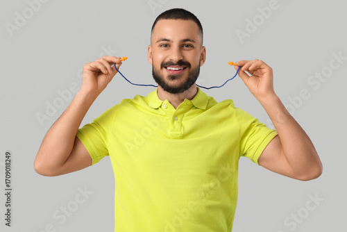 Young man putting earplugs ...