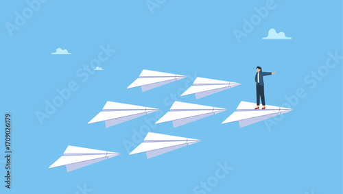 Smart confidence businesswoman standing on leading flying paper airplane origami pointing finger to the direction to reach goal. Business leadership, woman power to lead company to achieve target.