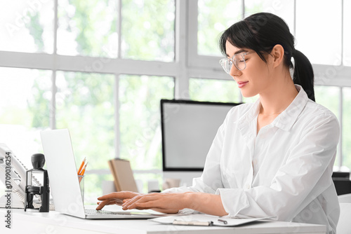Young secretary working  with laptop in office