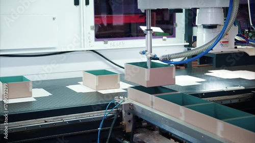 Innovative robotics at work in a box manufacturing plant gluing cardboard for efficient production