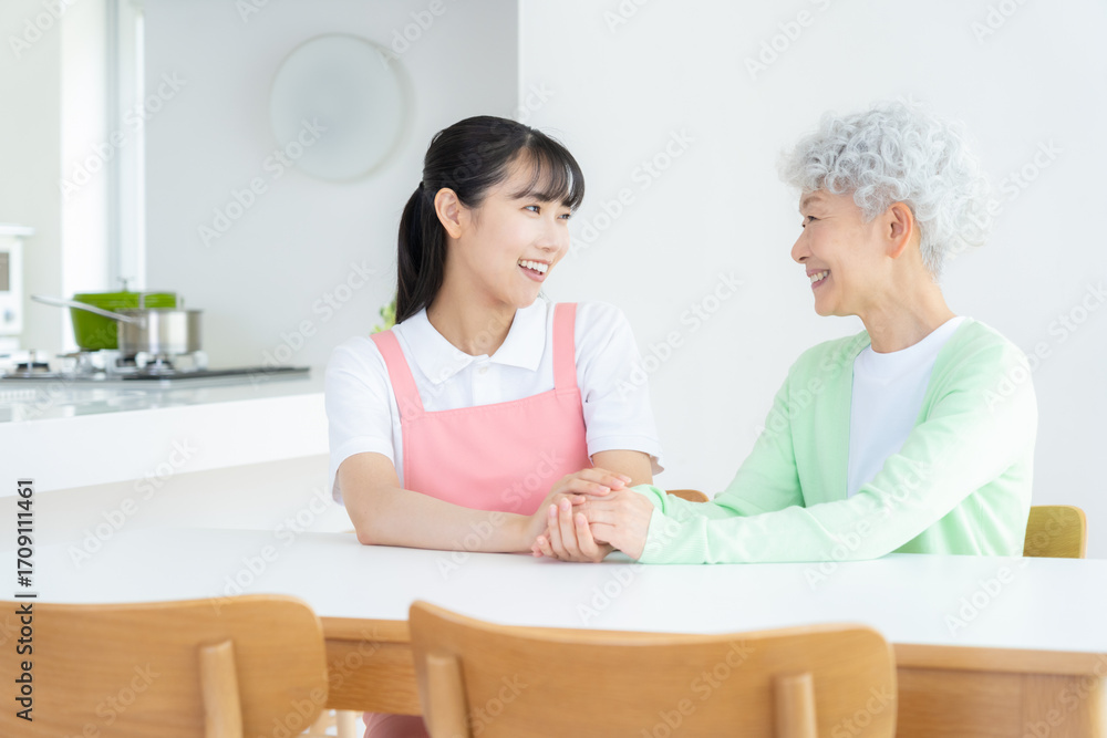 Fototapeta premium 高齢者を介護する若い女性介護士