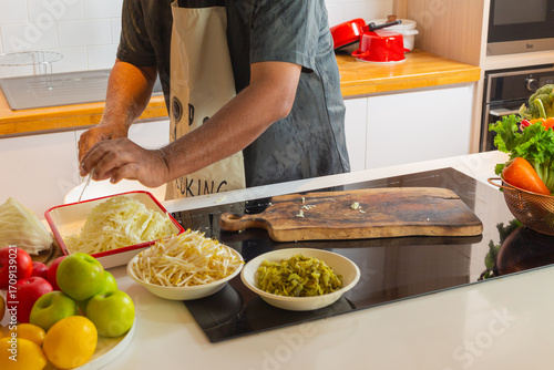Man Preparing Fresh Cabbage and Bean Sprouts on Kitchen Counter