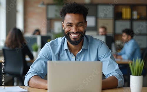 Modern Office Businessman Working on Computer. Portrait of Successful Latin IT Software Engineer Working on a Laptop at his Desk. Diverse Workplace with Professionals. Front View Shot. High quality