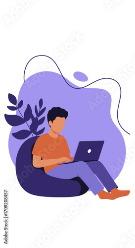 Casual young man focused on his laptop, working from home or engaging in online learning on a comfortable bean bag chair. Modern remote lifestyle.