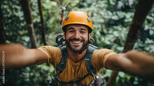 Fototapeta Naklejka Na Ścianę i Meble -  Smiling Man Ziplining Through Lush Rainforest Canopy