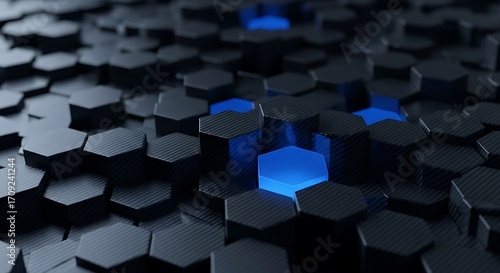 A digitally rendered design showcasing a pattern of dark hexagons, with one glowing bright blue hexagon in the middle.