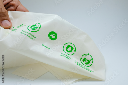 Hand holding a white recycled plastic bag with recycle symbol. Suitable of sustainability, recycling, waste management, and eco-friendly packaging, green campaign, educational materials