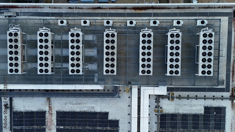 Obraz premium Top down aerial view of data centre cooling fans, turbines, information computer cooling air conditioning units England UK