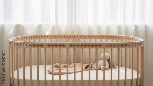 Oval baby crib with leaf design wooden frame and soft plush bunny for nursery room decor and baby sleep