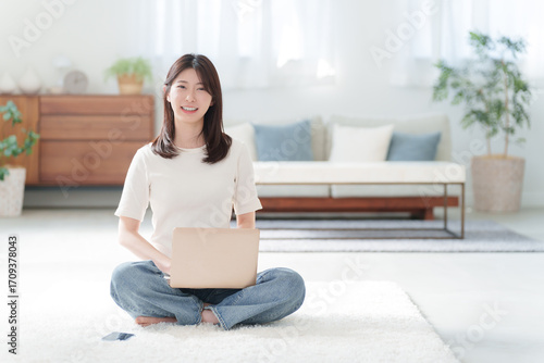 家でパソコンを使って仕事する女性
