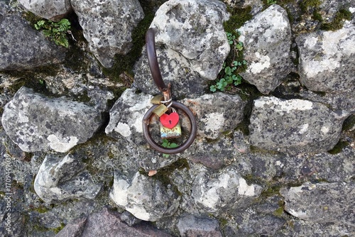 a rusty round handle attached to a stone wall