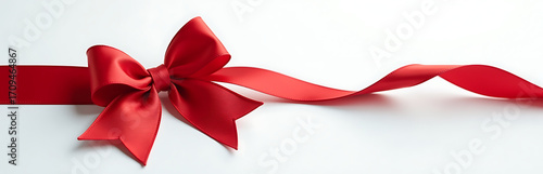 delicate red satin ribbon bow lies elegantly pristine white background intricate folds curved shape illuminated soft