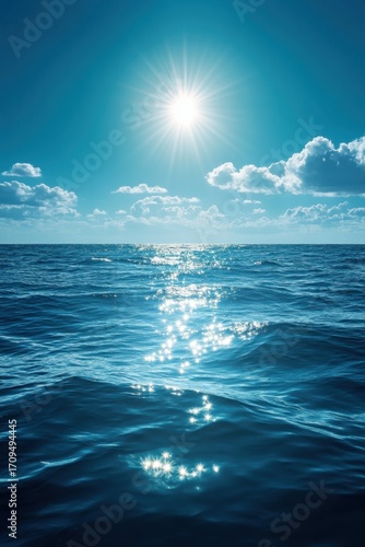 Bright sun over blue sea with shining water and clouds on horizon symbol of summer nature peace travel beauty