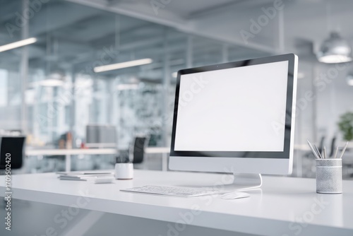 blurred background of a modern office interior with a white desk and computer monitor mockup, a minimalist work space for a graphic designer or web developer, with copy space.