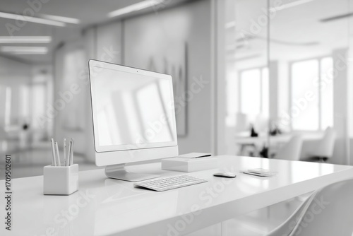 blurred background of a modern office interior with a white desk and computer monitor mockup, a minimalist work space for a graphic designer or web developer, with copy space.