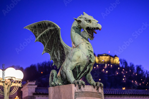 Dragon bridge and the Dragon statue with the Ljubljana castle at night