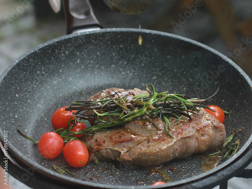 Pan-fried steak with red tomatoes and rosemary