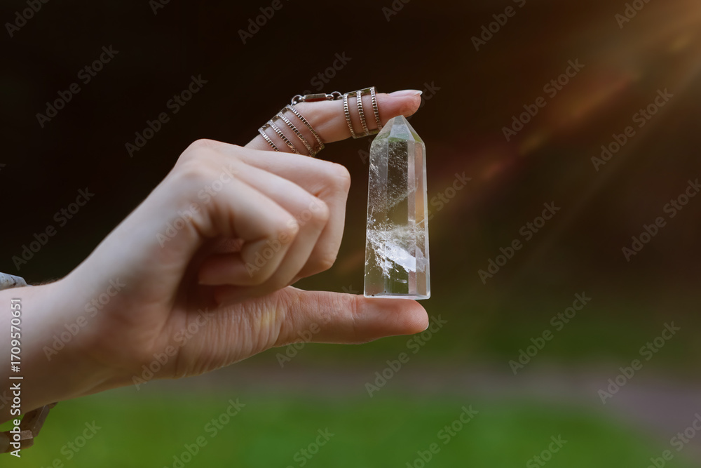Obraz premium Woman meditating with crystal to heal or restore her aura outdoors, closeup
