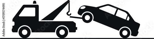 Tow truck lifting a car for transport, illustrating roadside assistance or vehicle recovery.