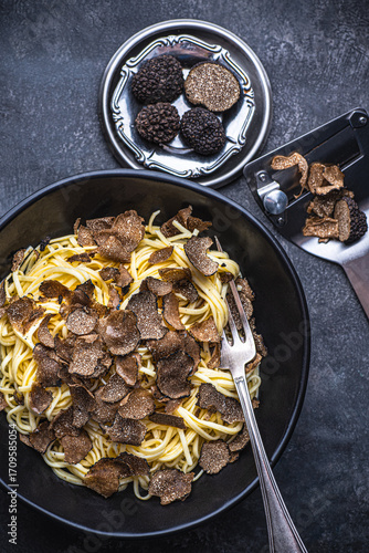 Wallpaper Mural Black truffle pasta Tajarin. Black rustic table, magical autumn light, top view. Autumn gourmet cuisine of Piedmont, Northern Italy, Spain and France, close up Torontodigital.ca