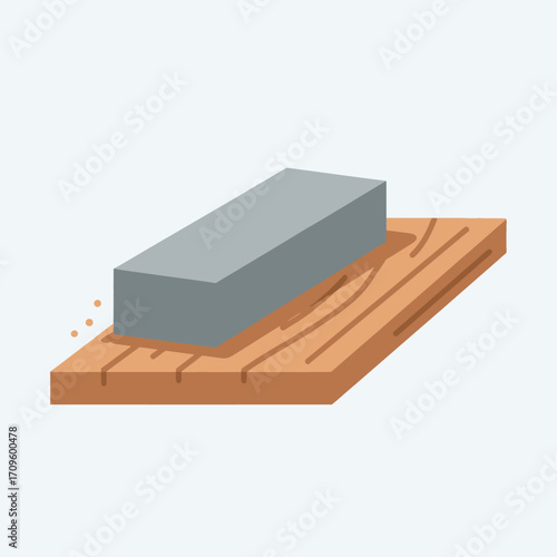 Close-up flat lay image of a grey sharpening stone honing a wooden surface, showing wood shavings, with neutral color tones against a white background.