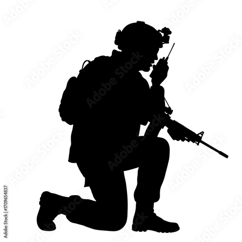 Silhouette of a soldier kneeling with rifle and radio in military action pose ready for duty