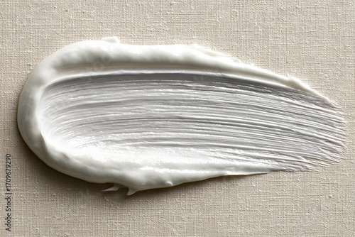 Creamy white substance smear on beige surface