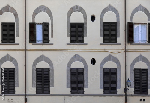 Tableau sur toile Rows of stone pointed arches above rectangular windows on the plastered, cream-color wall of a building in Piazza Mentana Square