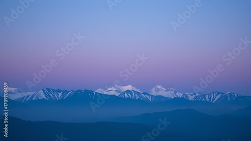 Majestic mountain range during blue hour, with a soft gradient of twilight colors.
