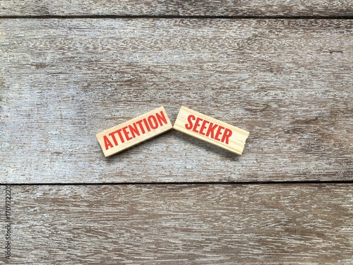 Attention Seeker word on two wooden blocks isolated on wooden surface. 