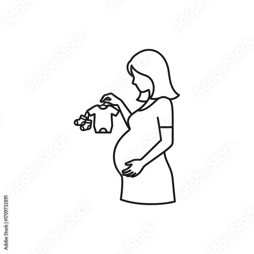 Pregnant woman gently holds baby clothes, anticipating motherhood.