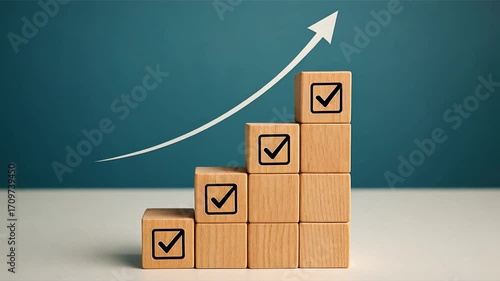 Wooden blocks arranged in spiral stack with checkmark icons rising higher arrow line moving upward on teal background symbolizing growth and progress