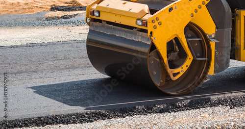 Heavy equipment for earthworks and landscaping. Close-up of a road roller compacting asphalt. Earthworks and road construction.