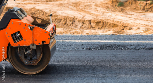 Heavy equipment for earthworks and landscaping. Close-up of a road roller compacting asphalt. Earthworks and road construction.
