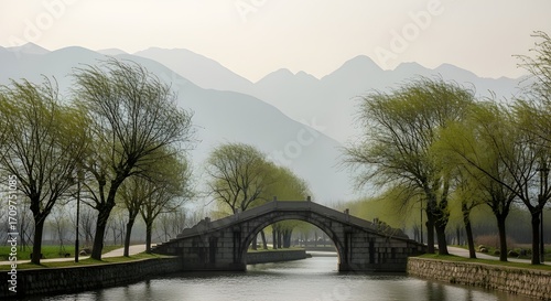 Ancient Stone Bridge Over River with Spring Trees and Misty Mountains – Peaceful Scenic Landscape