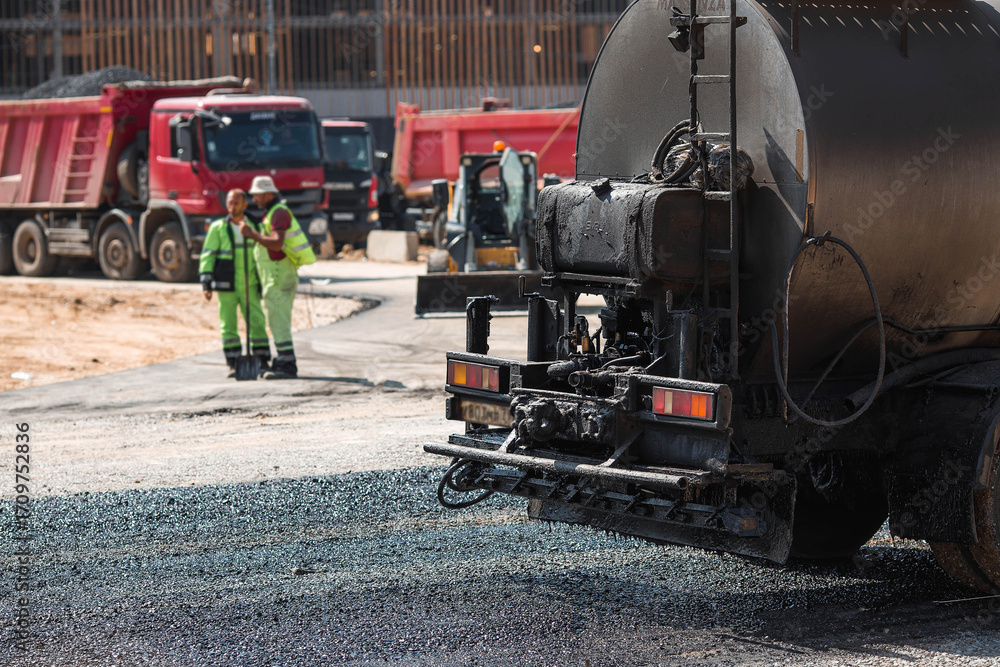 Naklejka premium Heavy equipment for earthworks and landscaping. Close-up of a tanker truck with bitumen. Preparing for asphalt laying. Road construction.