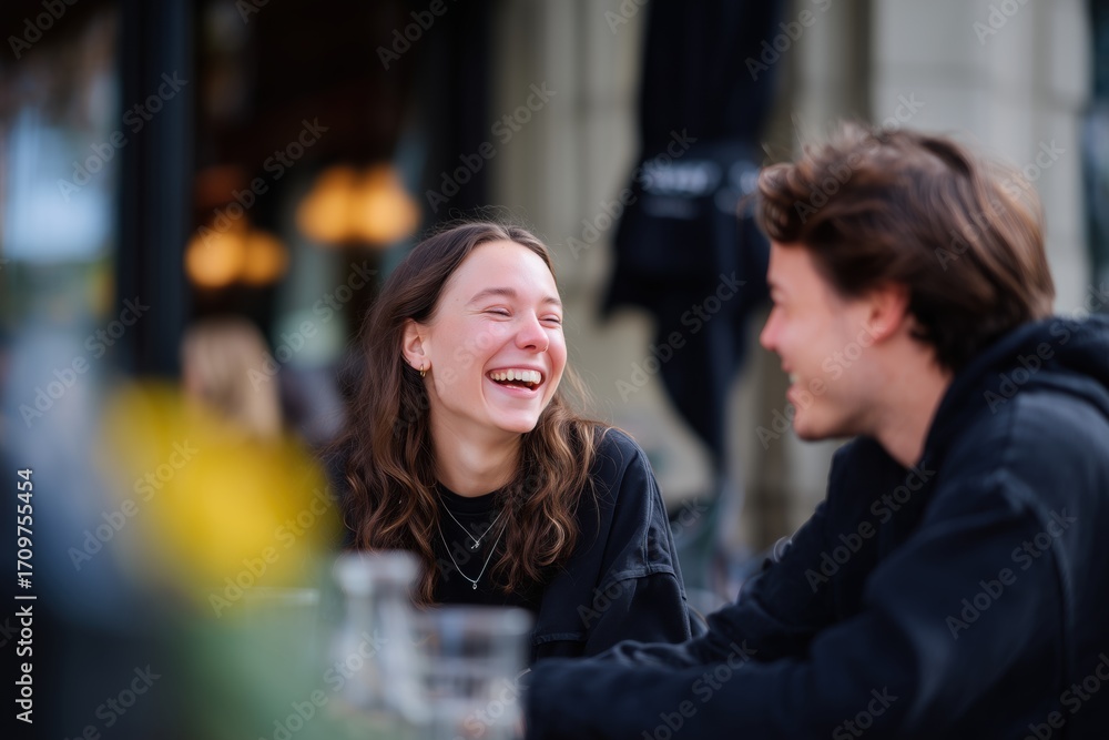 Fototapeta premium Two people enjoying a lively conversation at an outdoor café