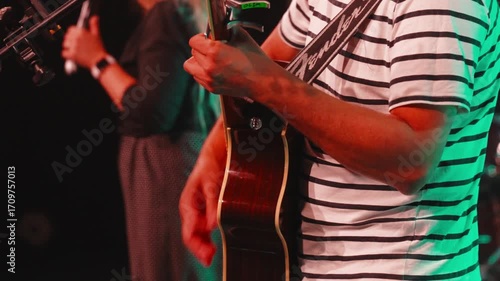 Acoustic guitarist playing worship music, generating spiritual ambiance through passionate instrumental performance during church evening service