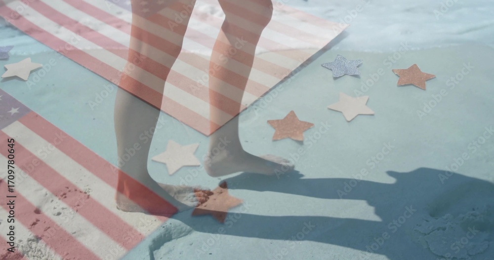Fototapeta premium Stepping bare feet on sandy painted surface at beach edge, with striped towel, star-shaped cutouts