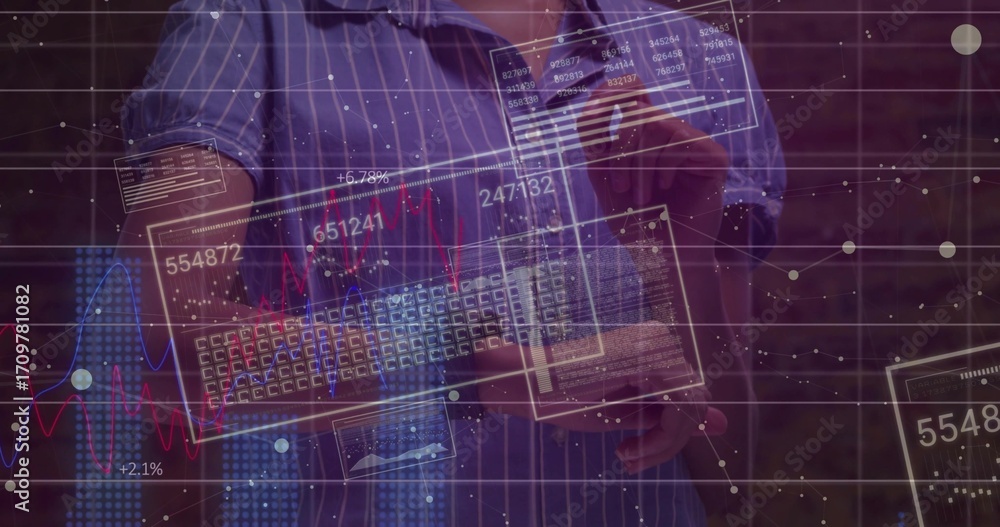 Fototapeta premium Man wearing blue shirt holding keyboard, swiping data panels at brick wall with holographic charts