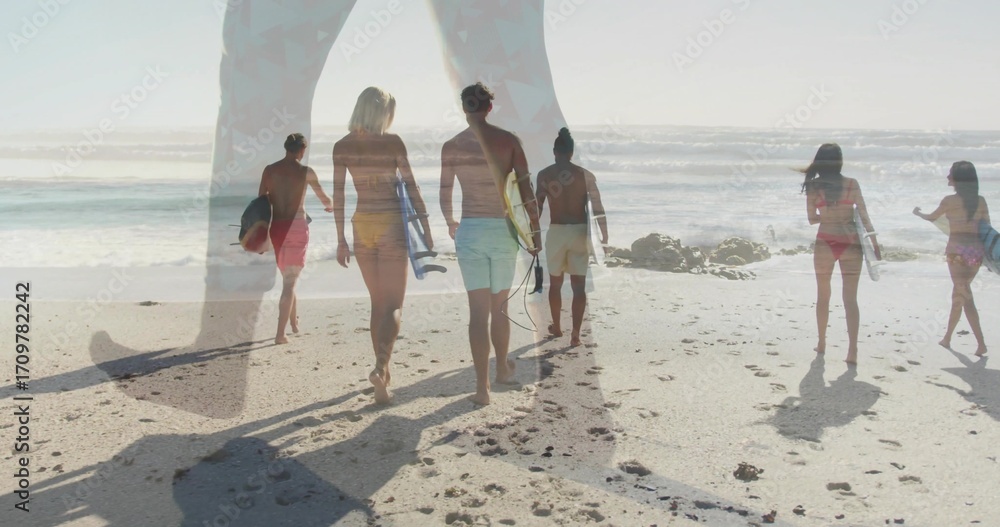 Obraz premium Walking surfers in swimwear carrying surfboards along beach at low tide with outcrop and footprints