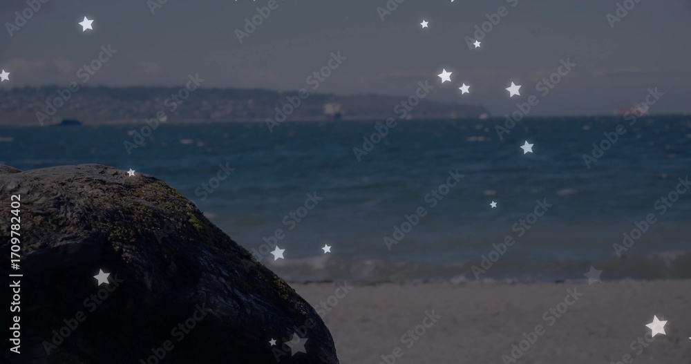 Fototapeta premium Moss-covered rock resting on sandy beach, with gentle waves and star-shaped overlays, copy space